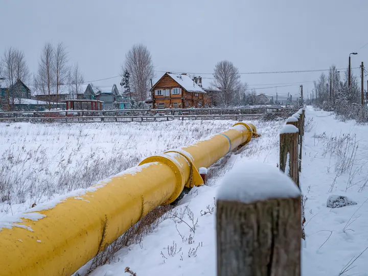 Надземный распределительный газопровод в посёлке зимой (изображение)